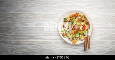 Traditional Levant dish Fattoush salad, Arab cuisine, with pita bread croutons, vegetables, herbs. Healthy Middle Eastern vegetarian salad, rustic woo Stock Photo