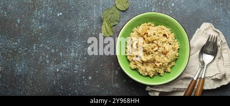 Ven Pongal (Khara Pongal), traditional Indian savoury rice dish made during celebrating Pongal festival, served in bowl top view on concrete rustic ba Stock Photo