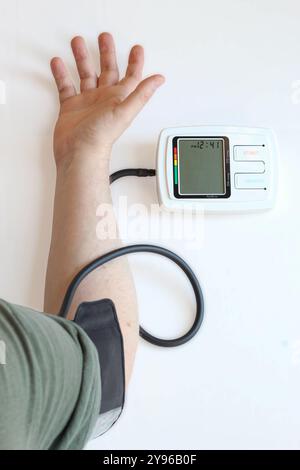 Taking blood pressure with device, overhead view, checking for hypertension. Stock Photo