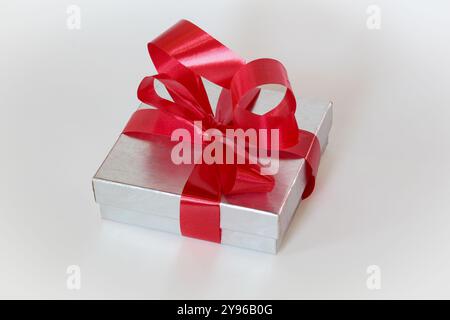 Silver gift box with red ribbon bow on white background Stock Photo