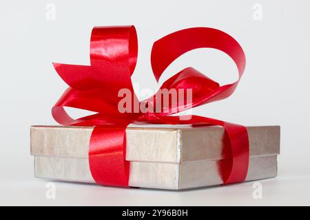 Silver gift box with red ribbon bow on white background Stock Photo