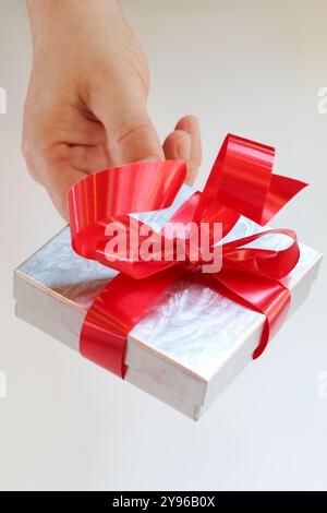Silver gift box with red ribbon bow on white background Stock Photo