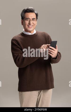 Happy senior man using smart phone Stock Photo