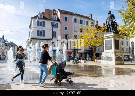 Lons-le-Saunier (central-eastern France): two women with child and stroller walk through 'place de la Liberté' square Statue of General Lecourbe and w Stock Photo