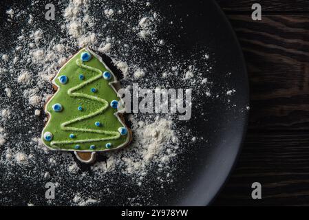 New year homemade gingerbread as firtree on the plate on dark wooden background. New Year or Christmas holiday concept Stock Photo
