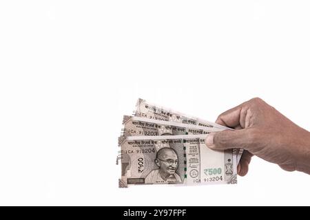 Hand hold Indian New Currency 500 rupees. Bank Note on white background. Unrecognizable hand of a man holding five hundred Indian rupees banknotes. Cl Stock Photo