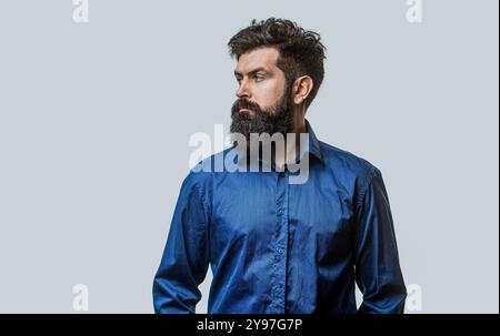 Male beard and mustache. Stylish bearded man in a blue shirt on a gray background. Bearded man, stylish hairstyle, beard. Perfect beard. Bearded man Stock Photo