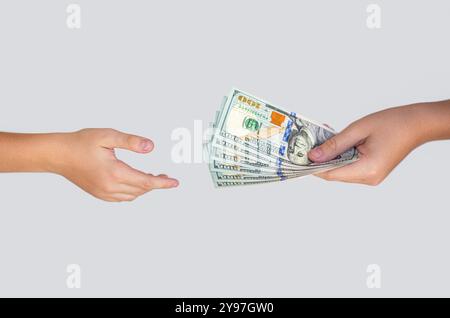 Money, cash. Handing over stacks of cash to other hand. Man giving dollar banknotes to woman. Female hand holding wad of hundred dollar cash bills Stock Photo