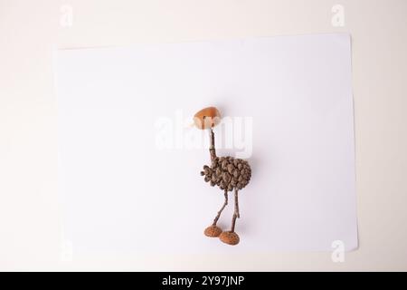 step in creative process, DIY, autumn craft, handmade bird crafted from pine cones, thin twigs or stems are used for the legs and neck Stock Photo