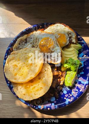 English muffin with fried eggs and avocado. Stock Photo