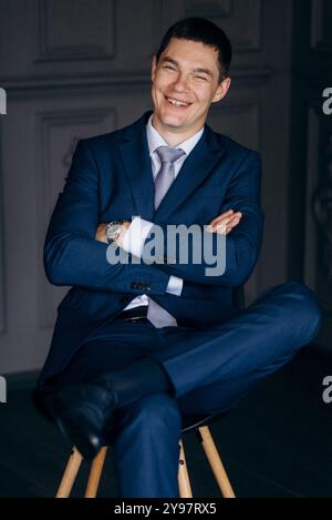 portrait of groom in blue three piece suit with tie on wedding day in hotel Stock Photo