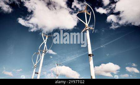 Vertical axis wind turbines against clouds in blue sky Stock Photo - Alamy