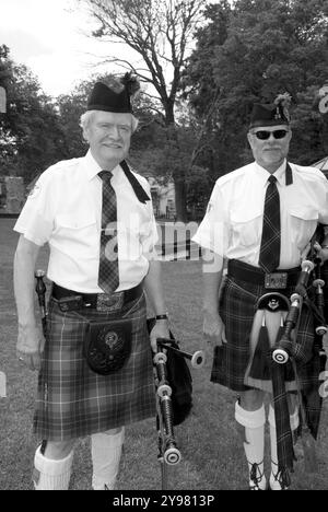 Two male Caucasian bagpipe musicians in red plaid kilts perform in the charming town of Blowing Rock, North Carolina, USA. Stock Photo