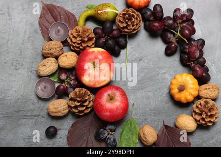 Autumn composition with apples, walnuts and leaves on grey background Stock Photo