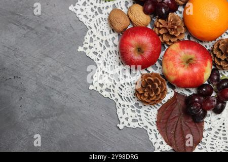 Autumn composition with apples, walnuts and leaves on grey background Stock Photo