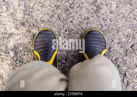 Construction worker wearing rubber work boots standing on gravel is taking a break. Selective focus Stock Photo