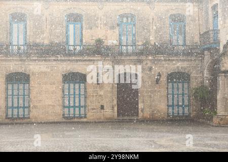 785 Hard tropical rain curtain almost hides the Casa Condes de Penalver House when viewed from across the Plaza Catedral Square, Old Town. Havana-Cuba Stock Photo