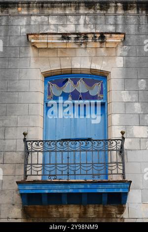 792 Closed blue wood door, iron railing, stained-glass transom light of small balcony, Palacio Marqueses Aguas Claras Palace first floor. Havana-Cuba. Stock Photo