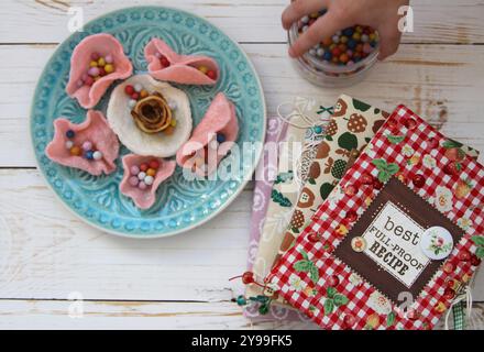 Handmade cook books and sweets on the wooden background and baby girl hand with sweets in jar Stock Photo