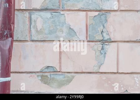 Weathered Wall Texture with Peeling Paint and Exposed Brick. Stock Photo