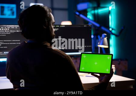Developer using isolated screen tablet to implement security measures, protecting company systems and data. IT admin testing and debugging code for applications on mockup portable device Stock Photo