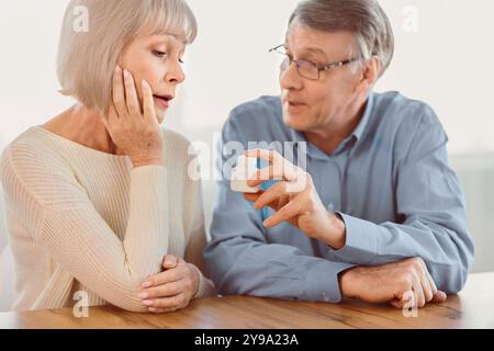 Mature man giving his wife some pills Stock Photo