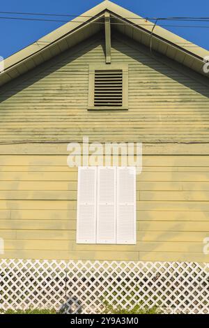 Yoakum, Texas, United States. White shuttered window on a yellow painted house. Stock Photo
