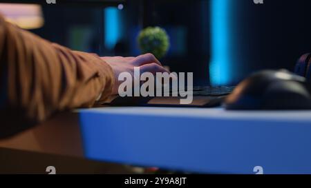 Focus on computer peripherals used by programmer to write lines of code on PC screen. Close up shot of keyboard and mouse used by developer working on fixing database errors, camera A Stock Photo