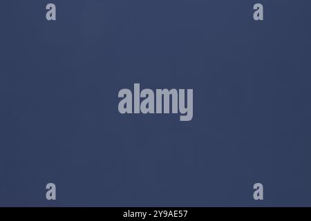 This paper background in a uniform navy blue color with slight variations in shading, creating a subtle texture, is perfect for various uses. Stock Photo