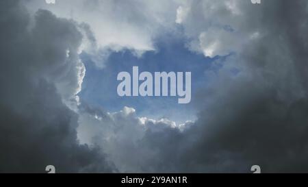 Dark storm clouds and the hole with a piece of blue sky Stock Photo