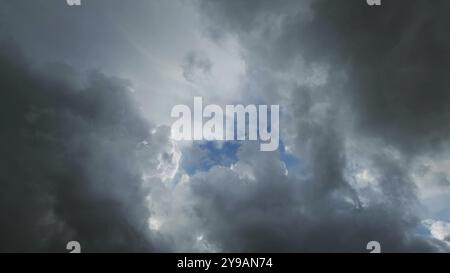 Dark storm clouds and the hole with a piece of blue sky Stock Photo