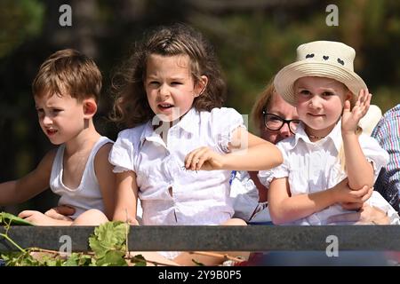 Badacsony, Lake Balaton, Hungary - September 8 2024: Wine harvest festival street parade, three young children dressed in white on a carriage Stock Photo