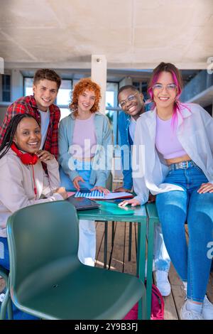 Happy diverse group of students studying in the library looking at camera Stock Photo