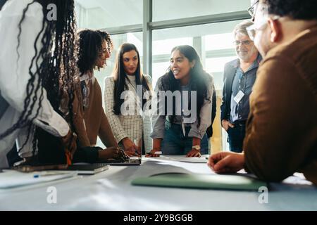 A diverse team of professionals collaboratively brainstorming during a business meeting in a modern office environment. Stock Photo