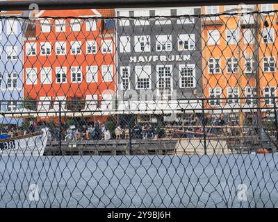 Copenhagen, Denmark - 9 October, 2022: A view through the chain-link fence towards the most touristy part of Copenhagen, with the old buildings along Stock Photo