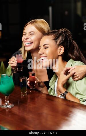 Two young colleagues enjoy laughs and drinks at a festive corporate gathering. Stock Photo