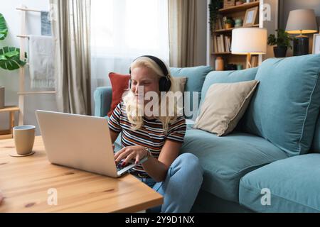 Young introvert freelancer businesswoman with ADHD working remotely from home office on laptop computer. Business person avoiding crowded office and p Stock Photo