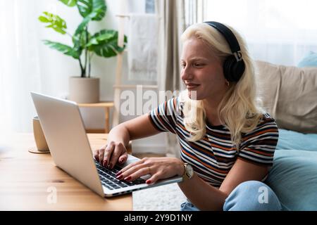 Young introvert freelancer businesswoman with ADHD working remotely from home office on laptop computer. Business person avoiding crowded office and p Stock Photo