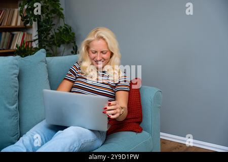 Young introvert freelancer businesswoman with ADHD working remotely from home office on laptop computer. Business person avoiding crowded office and p Stock Photo