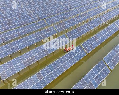 SUQIAN, CHINA - OCTOBER 10, 2024 - A worker checks photovoltaic equipment at a fishery-solar hybrid base in Suqian, East China's Jiangsu province, Oct Stock Photo