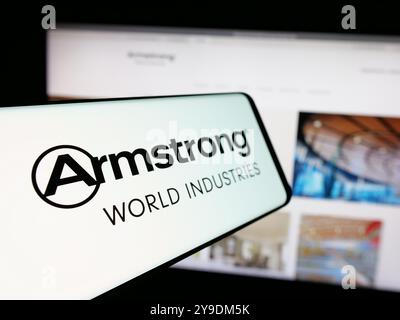 Cellphone with logo of American company Armstrong World Industries Inc. on screen in front of business website. Focus on left of phone display. Stock Photo