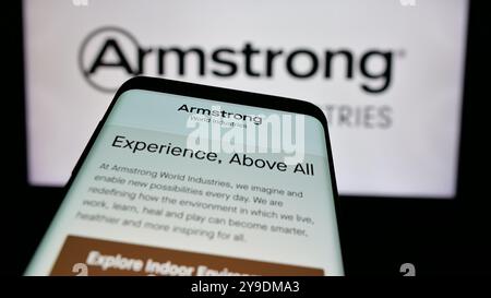 Mobile phone with website of US company Armstrong World Industries Inc. on screen in front of business logo. Focus on top-left of phone display. Stock Photo