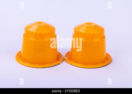 Close-up of yellow coffee capsules on a white surface. Bright and modern composition highlighting the vibrant product design for coffee brands Stock Photo