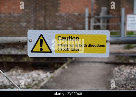 A warning sign at a footpath crossing at Kingswear on the Dartmouth Steam Railway, South Devon. Stock Photo