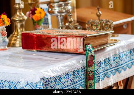 Elegantly Bound Holy Book Resting on an Ornately Set Table. Stock Photo