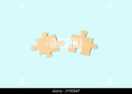 Yes and no single words written on brown puzzle pieces on a light blue background with copy space Stock Photo