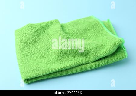 Clean green microfiber cloth on light blue background, closeup Stock Photo