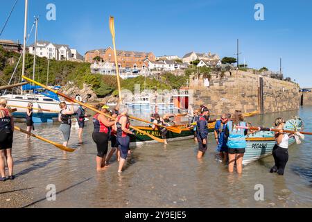 Pilot Gig crews carrying their oars waiting to board their Pilot Gigs for Women's Newquay County Championships Cornish Pilot Gig Rowing event at Newqu Stock Photo