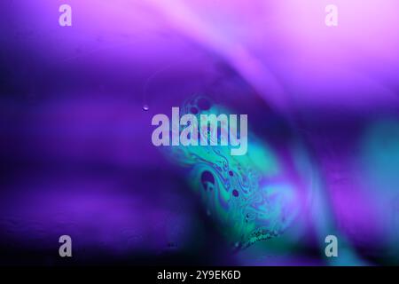 Bright reflection of liquid in macro, blue and silver colors, rainbow background, Blue bubbles in macro, connection of bubbles in macro Stock Photo