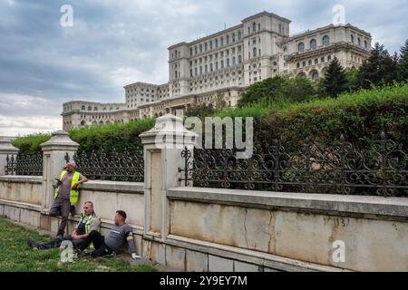 Workmen taking a break outside the Palace of the Parliament, Bucharest, Romania Stock Photo